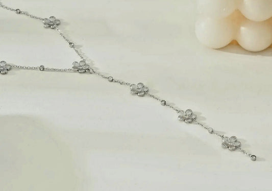 Collar de plata en forma de Y con delicadas flores.